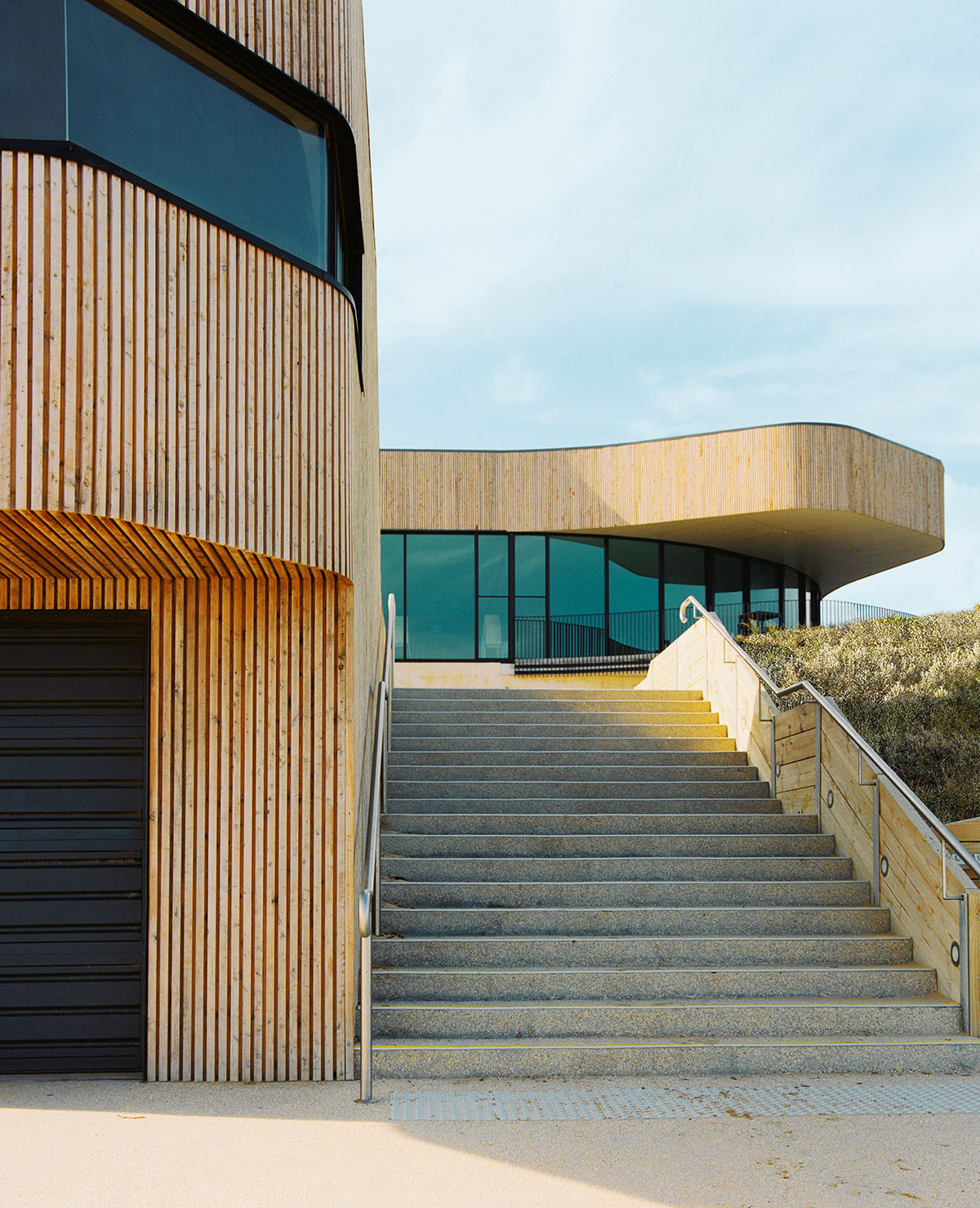 Wood Marsh completes surf club with timber rounded corners echoing ocean and eroded dunes