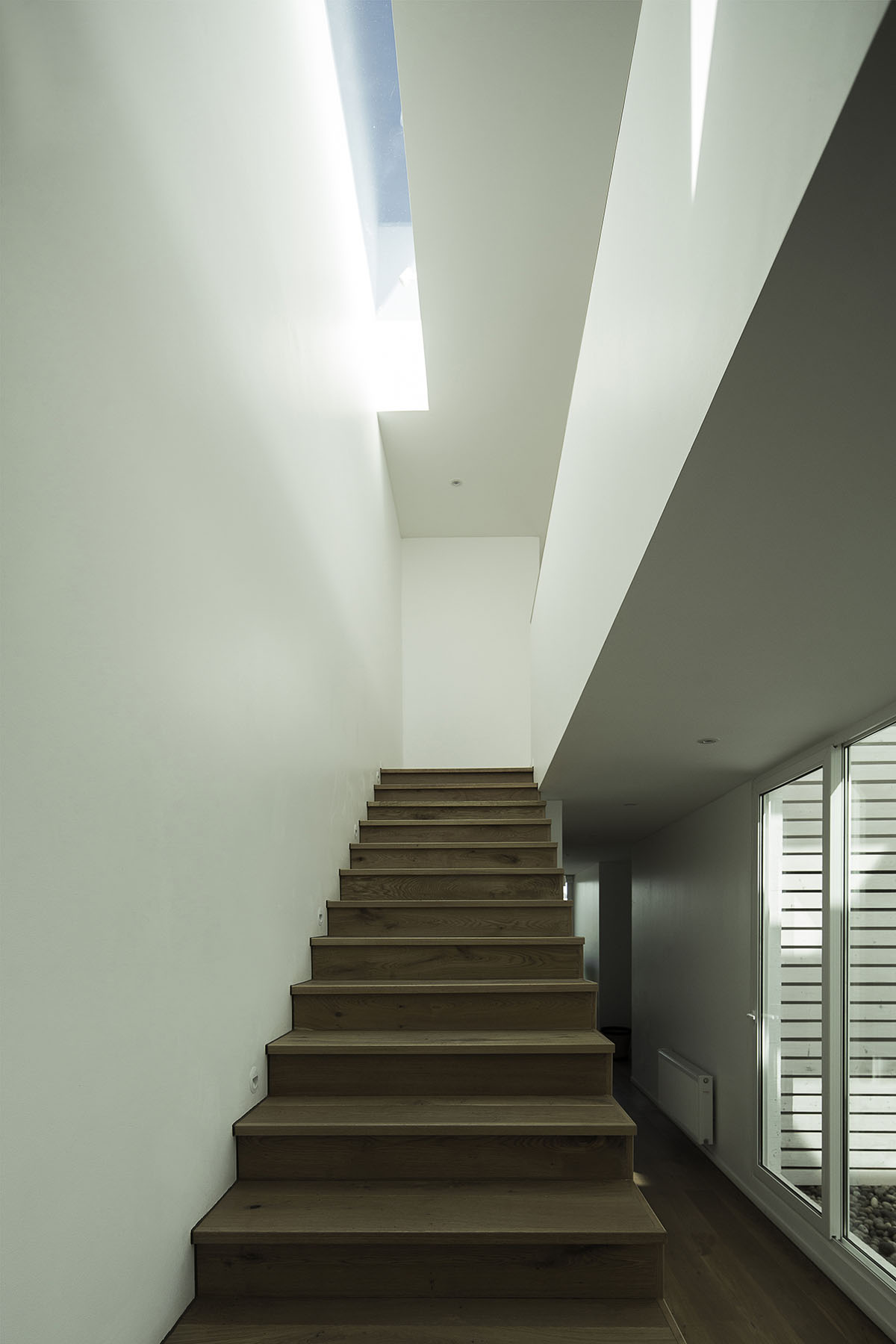 Cristián Romero Valente built this white concrete house on steep slope to give serene view in Chile