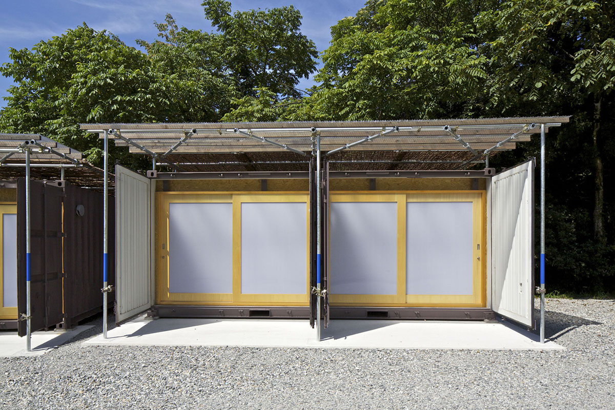 A multi-purpose venue is wrapped by living trees as an addition to open-air theatre in Japan