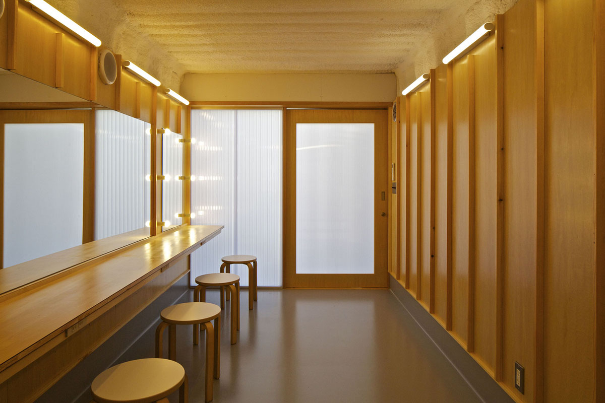 A multi-purpose venue is wrapped by living trees as an addition to open-air theatre in Japan