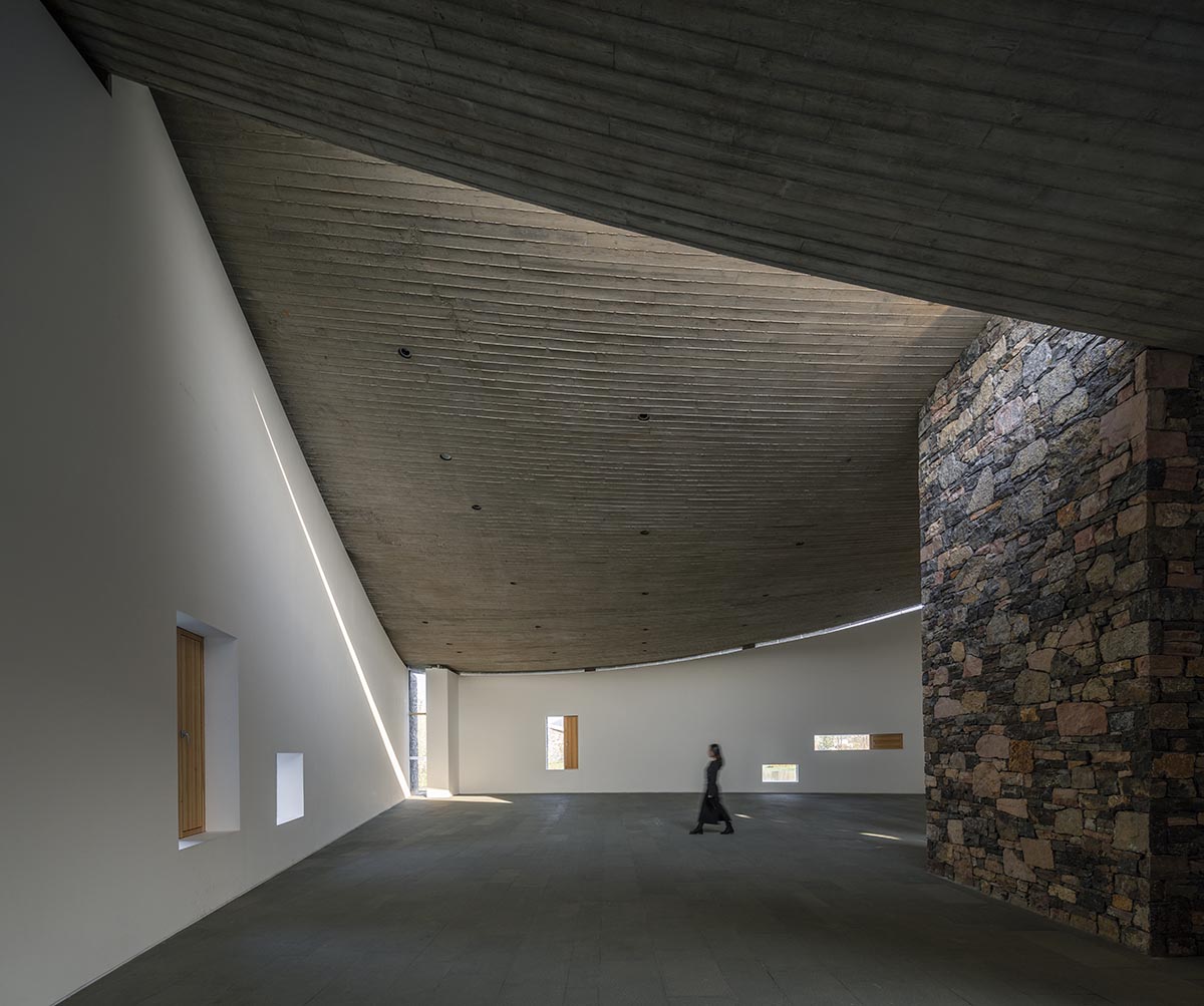 Concrete hyperboloid roofs cover masonry stone art center with a central courtyard in Shandong