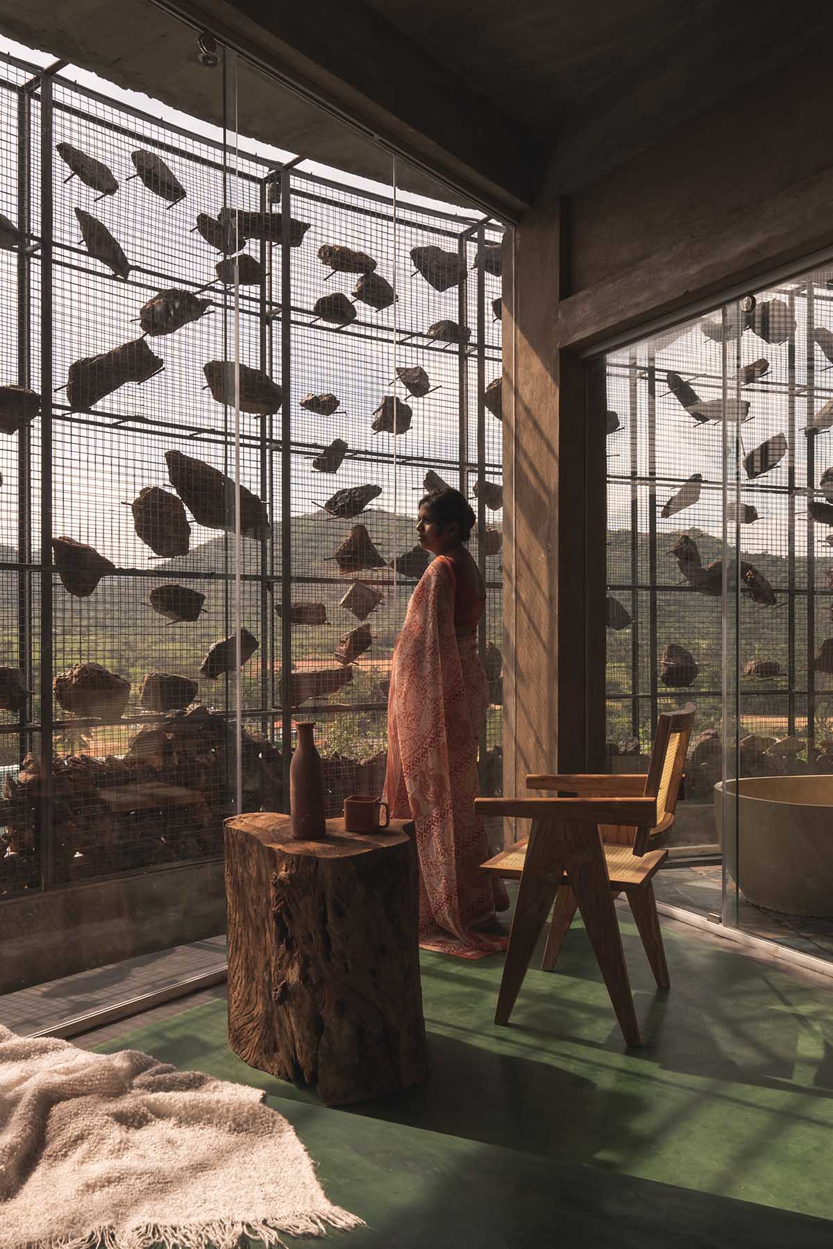 Farm house by Earthscape Studio is wrapped by gabion wall to filter light and airflow in India 