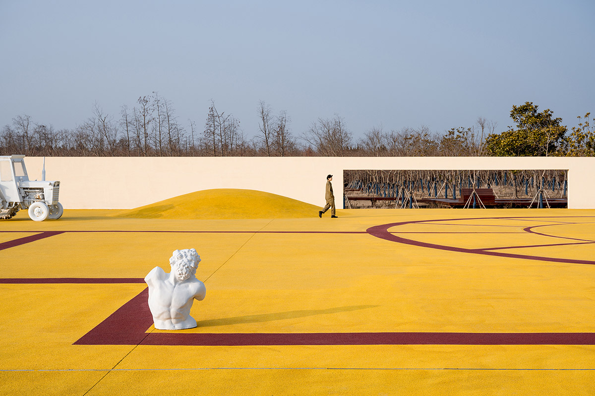 Wutopia Lab converts abandoned barnyard into a golden yellow field resembling a frozen harvest time