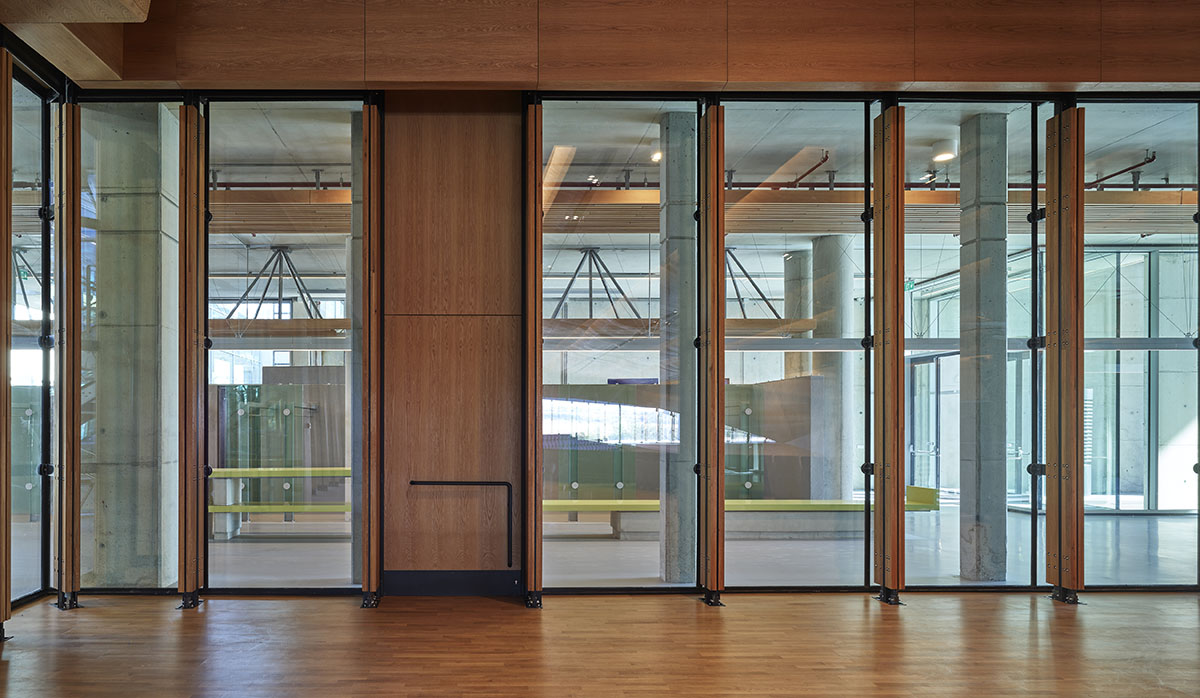 Uygur Architects articulates performing arts center façade with wooden triangulating surfaces