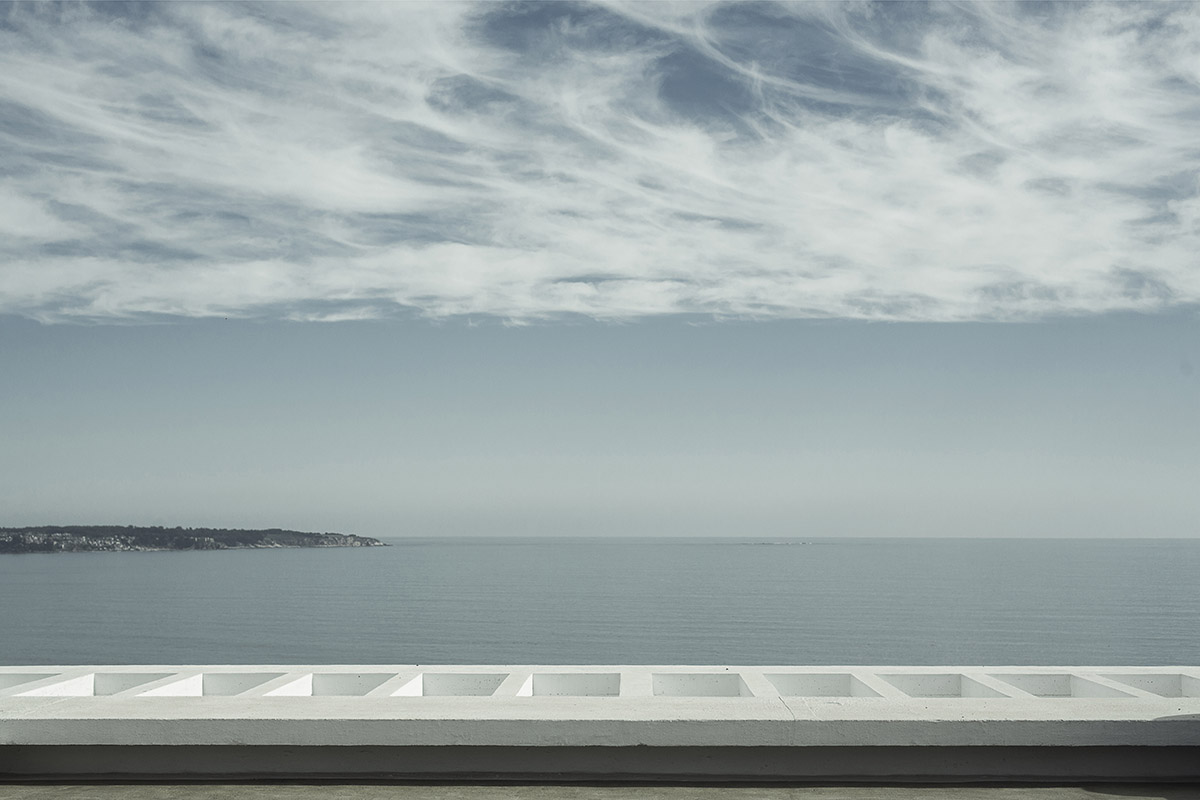 Cristián Romero Valente built this white concrete house on steep slope to give serene view in Chile