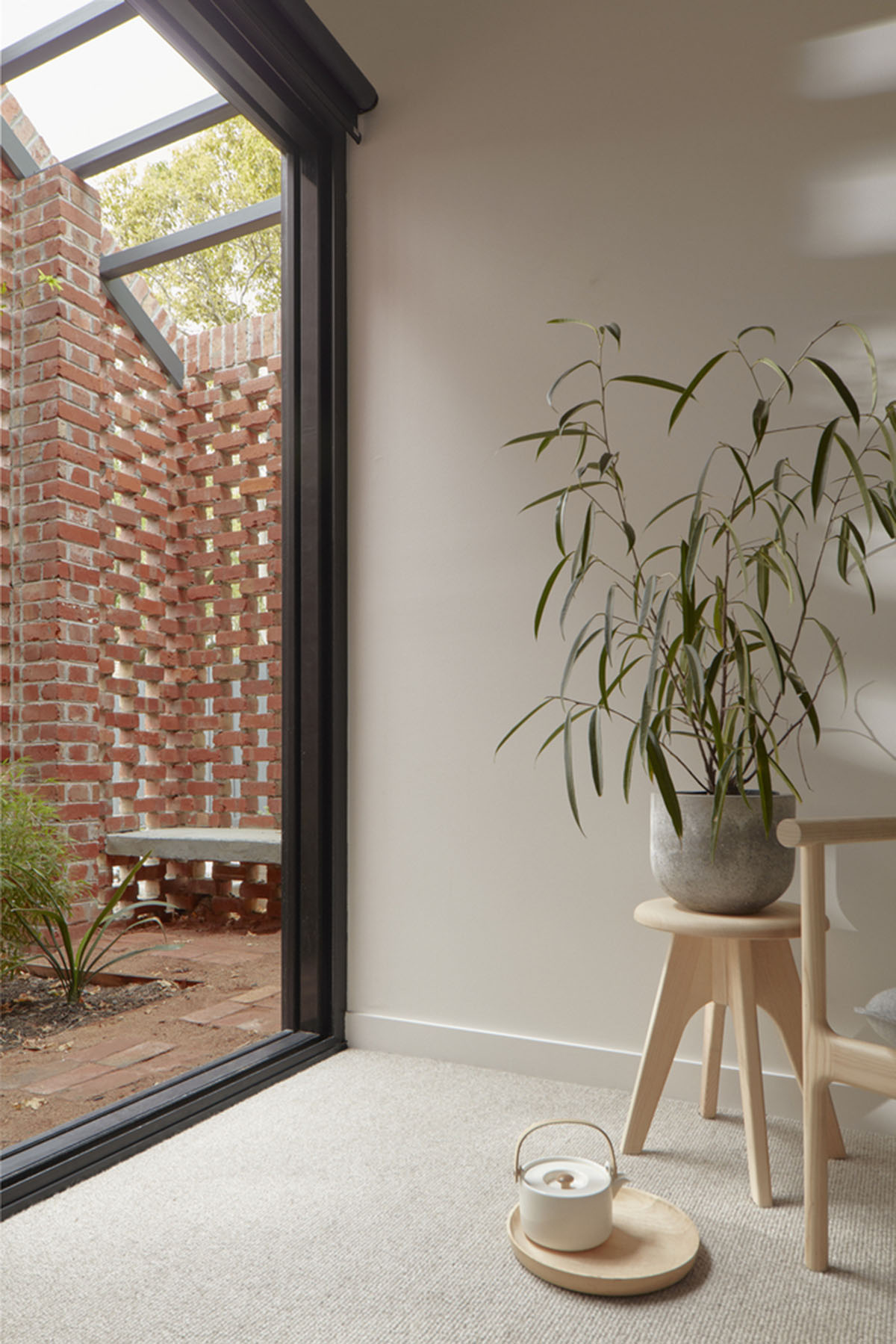 Recycled brick screens wrapping these two dwellings help thermal comfort in a suburb of Australia