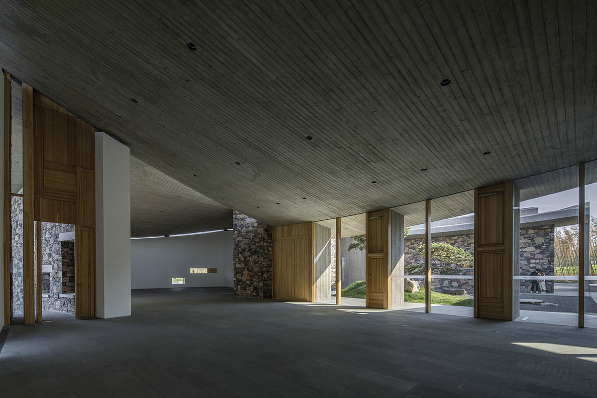 Concrete hyperboloid roofs cover masonry stone art center with a central courtyard in Shandong