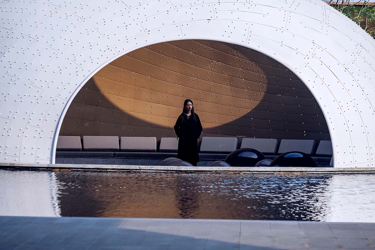 A thin-shell pavilion inspired by the bionic weaving appearance of birds’ nests sits on a pool