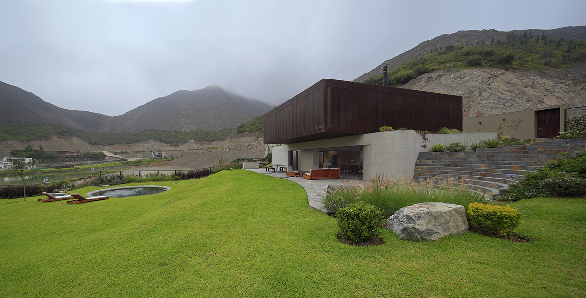 Large semi-buried social space creates a rustic and organic feeling under wooden volume built in Peru