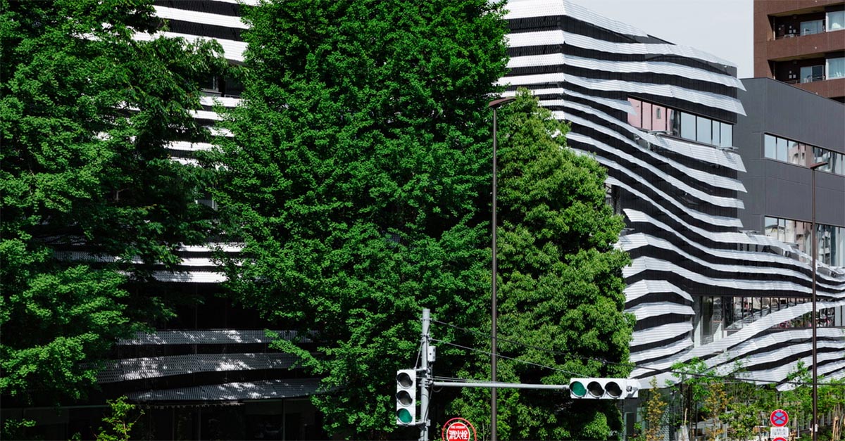 Kengo Kuma wraps alumni building in Tokyo with irregular metal surface creating organic skin