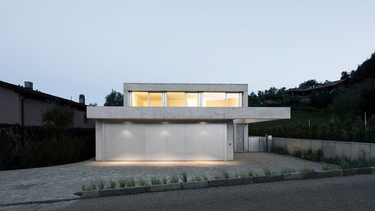 Grey concrete villa by DF_DC is characterised with trapezoidal colonnaded terrace on Comano hills
