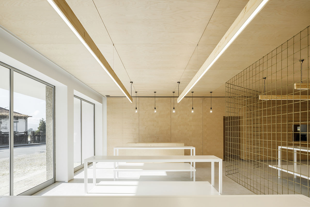 stu.dere divides interior space with golden wire meshes for multiple uses in this store in Portugal