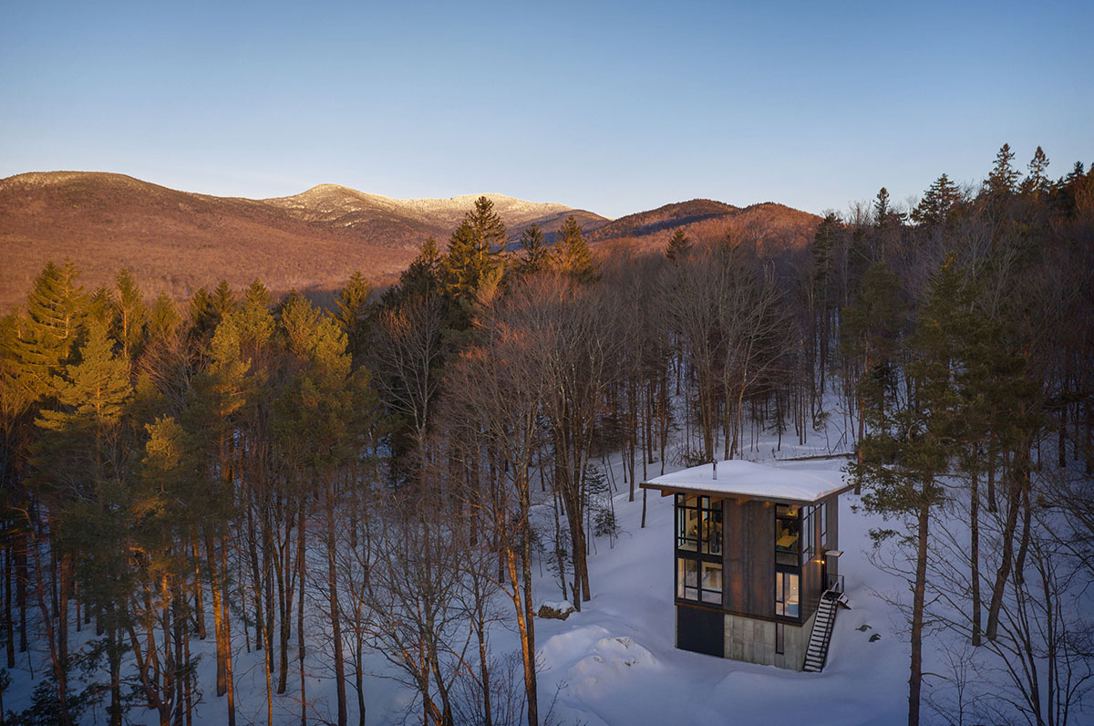 Olson Kundig creates compact and minimal family cabin in a heavily wooded landscape in Vermont