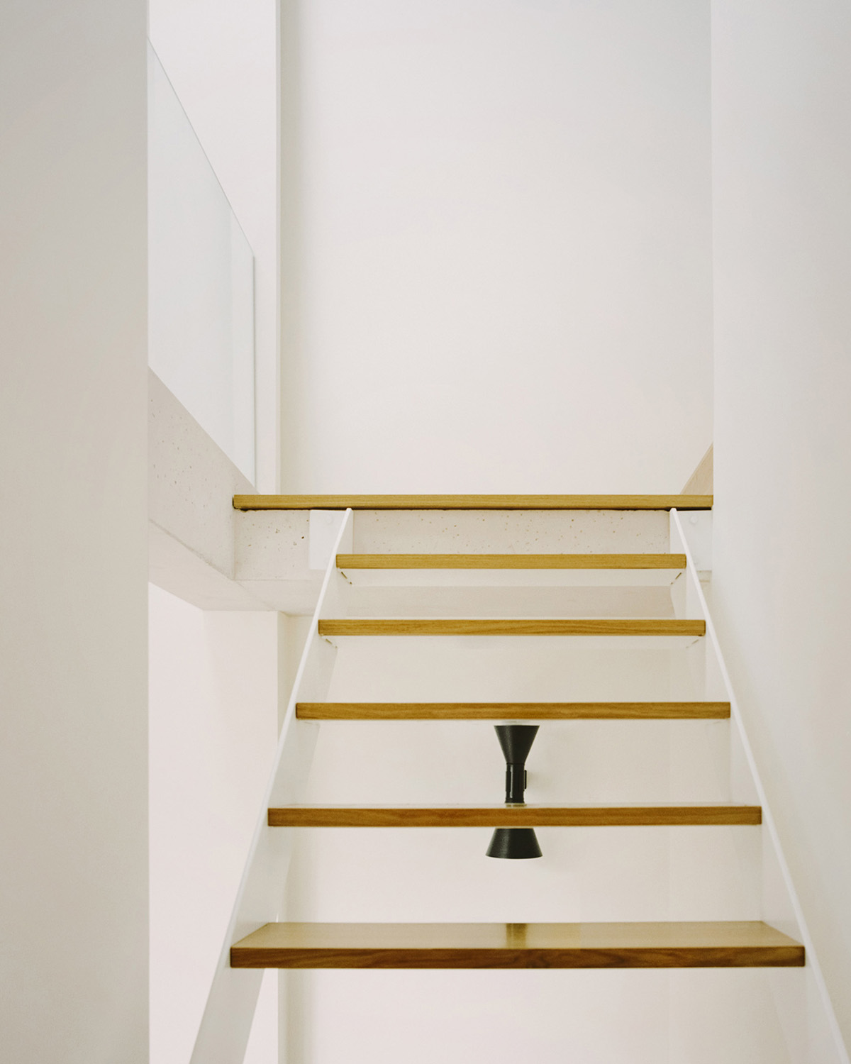 White concrete curved bridge gently complements interiors of The Island House in Paris