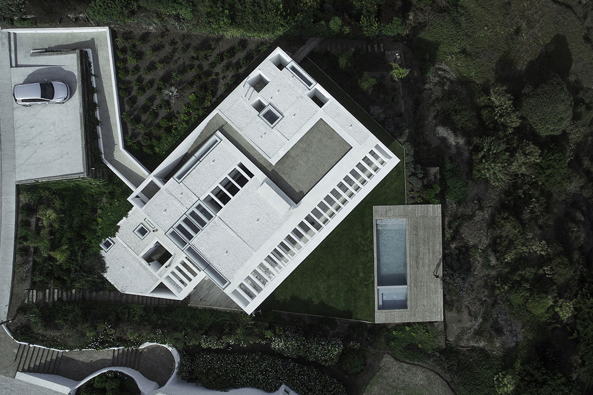 Cristián Romero Valente built this white concrete house on steep