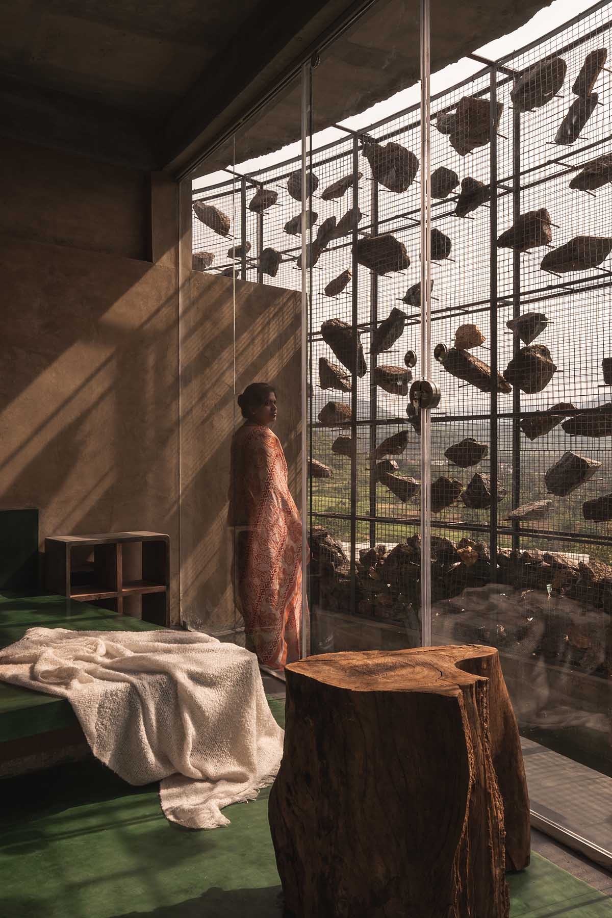 Farm house by Earthscape Studio is wrapped by gabion wall to filter light and airflow in India 