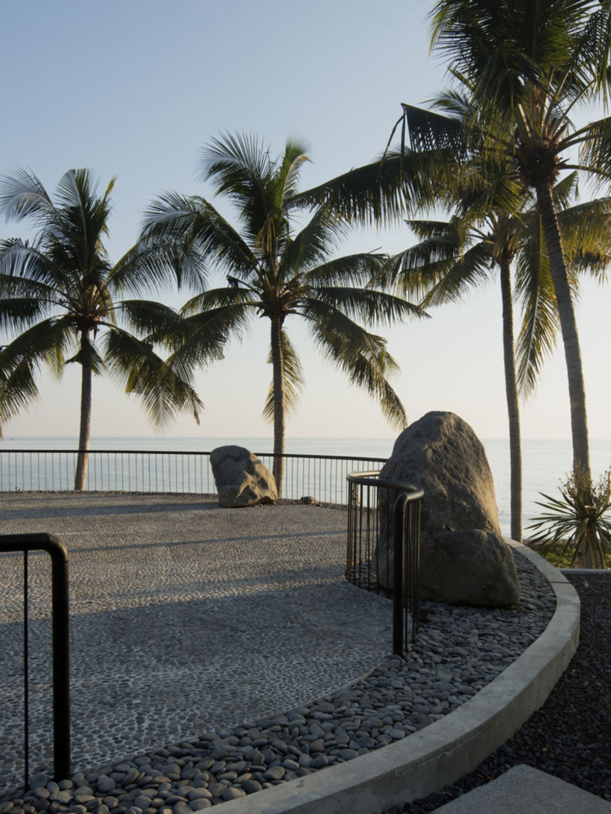 Linear concrete walls hide hotel rooms overlooking lush forest on the northern coast of Bali