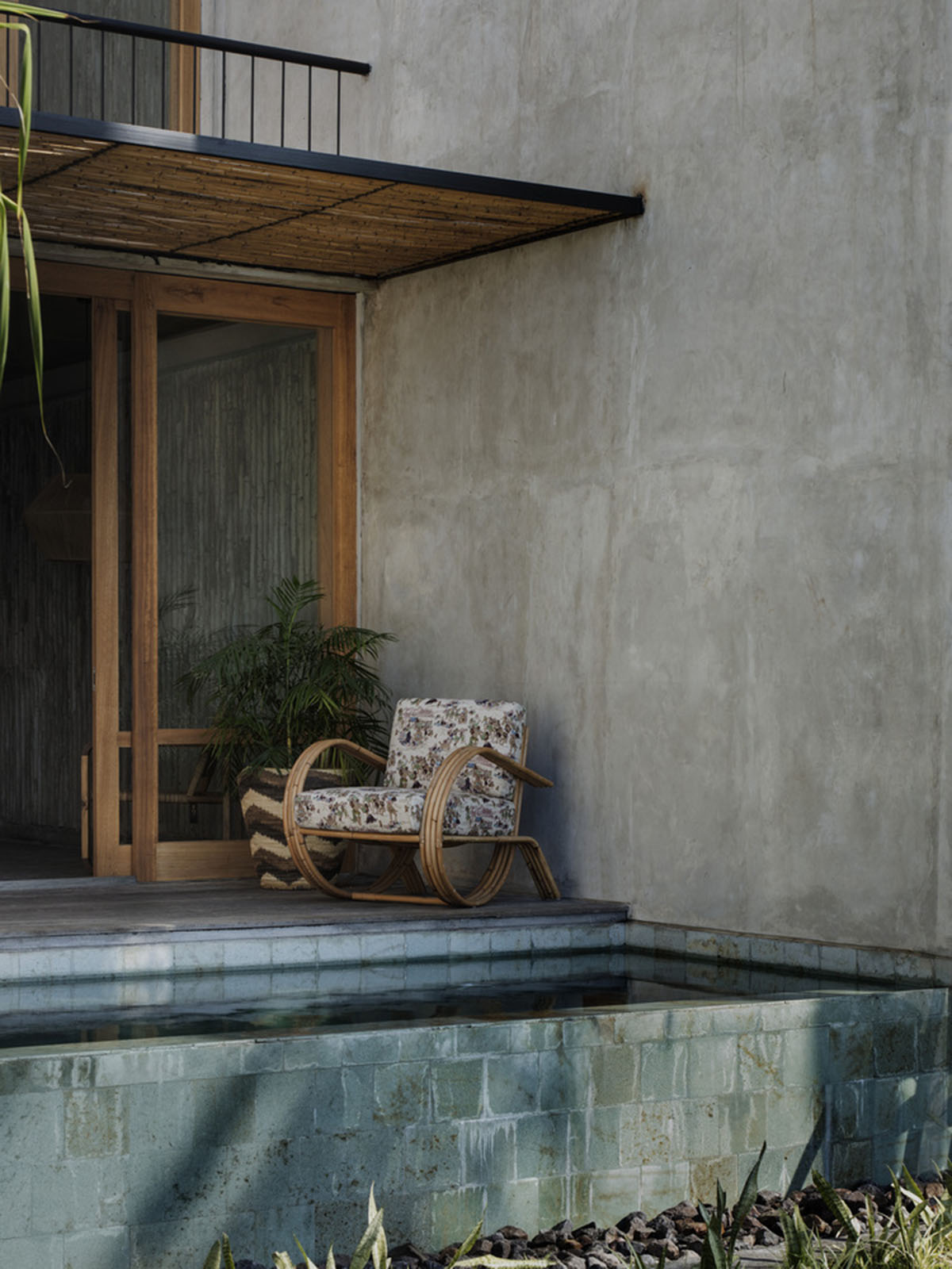 Linear concrete walls hide hotel rooms overlooking lush forest on the northern coast of Bali