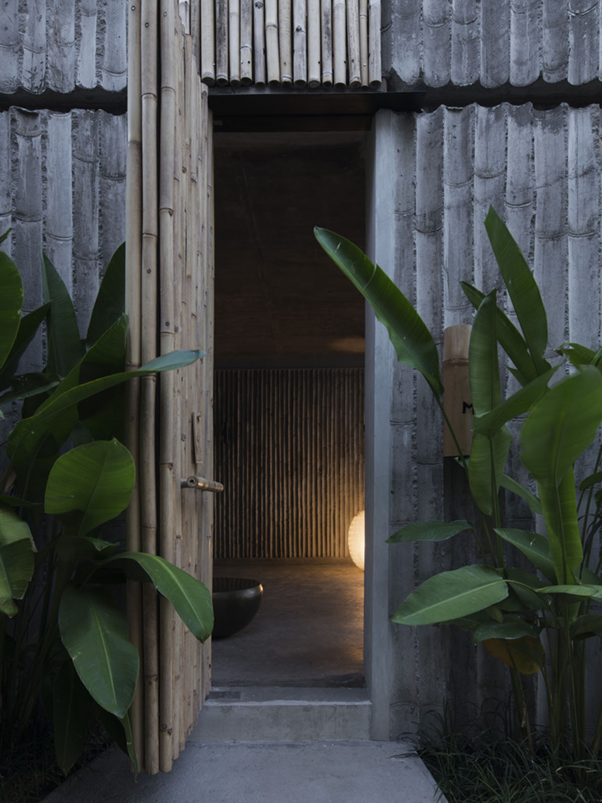 Linear concrete walls hide hotel rooms overlooking lush forest on the northern coast of Bali