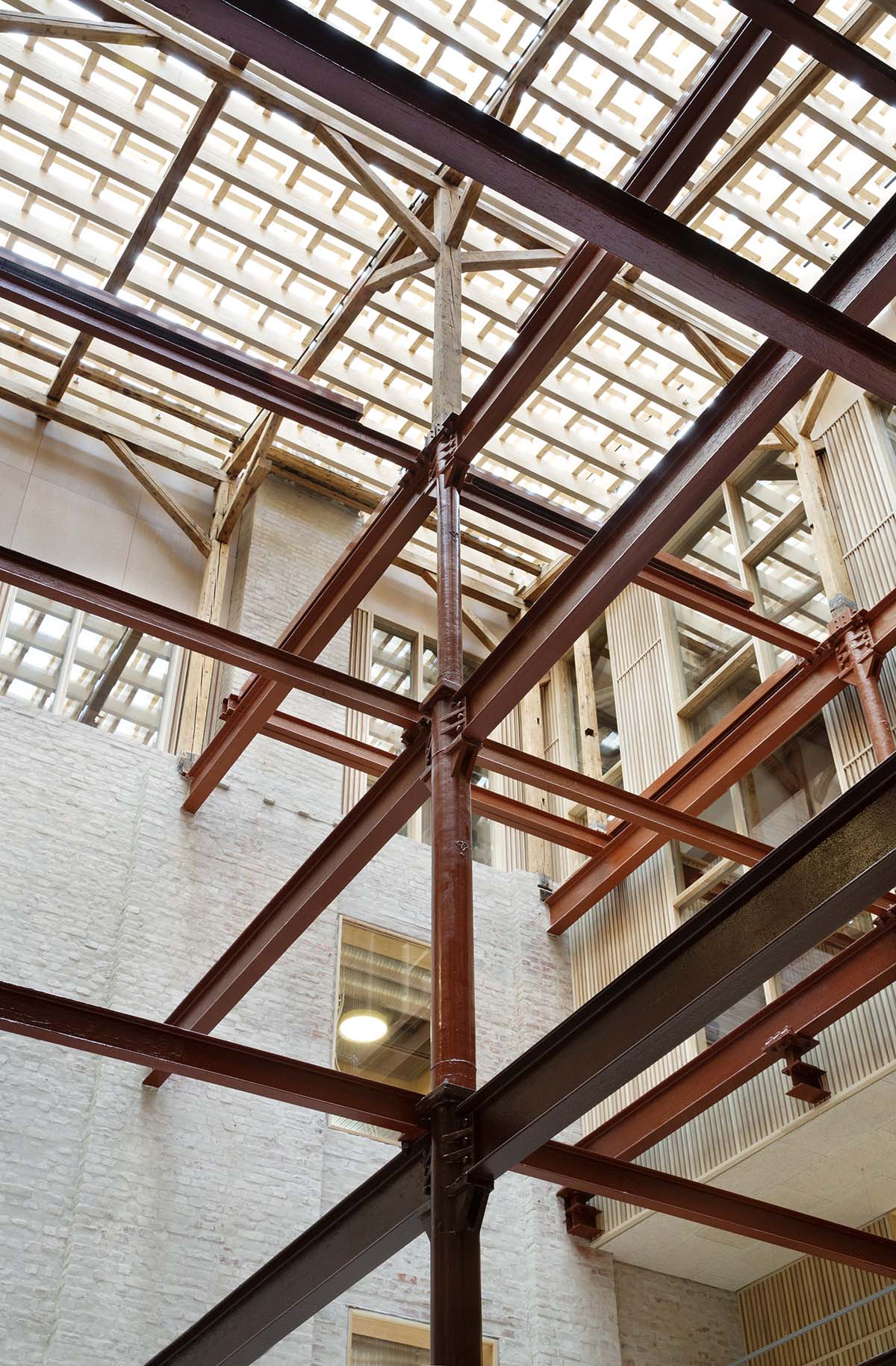 Atelier Oslo and KIMA Arkitektur restore former warehouse as a press house with light-lit atrium