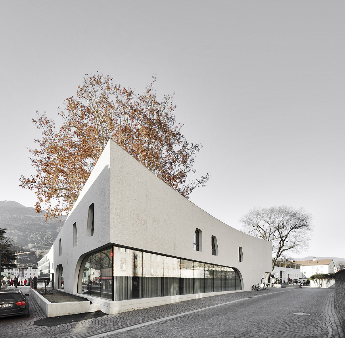 MoDusArchitects wraps public space with sinuous curves for an office building in Bolzano, Italy