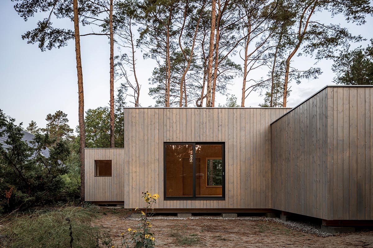 Zeller & Moye built private residence composed of interlocked timber cabins among pine trees