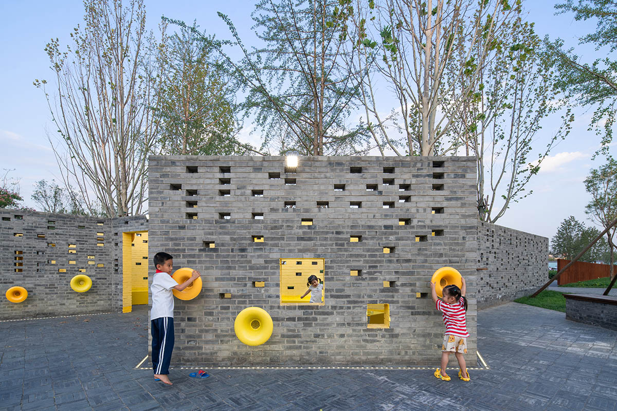 Crossboundaries designs community park with perforated grey brick walls and yellow track in Beijing 