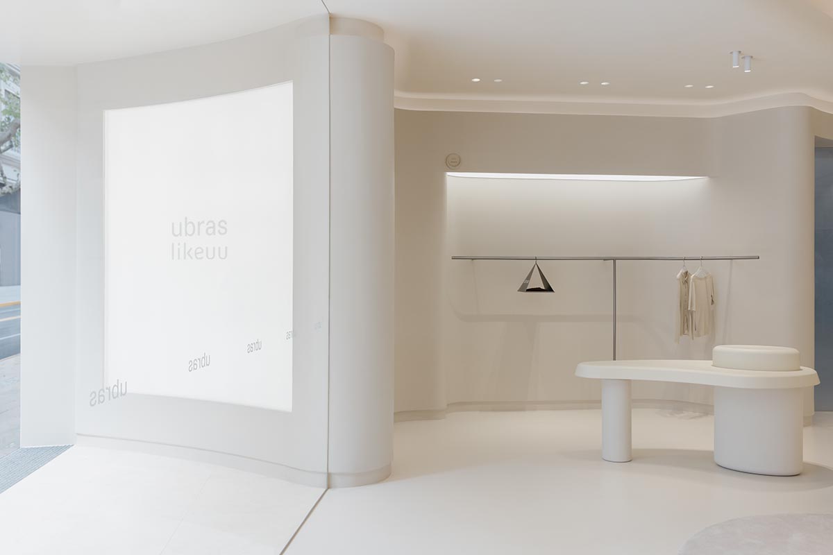 Store interiors by Sò Studio feature soft beige tones to give the feeling of