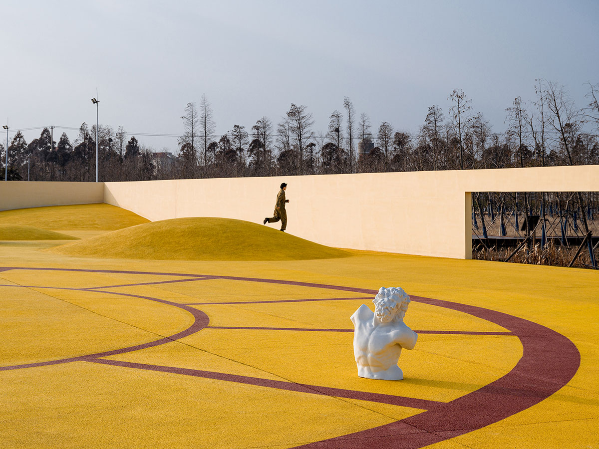 Wutopia Lab converts abandoned barnyard into a golden yellow field resembling a frozen harvest time