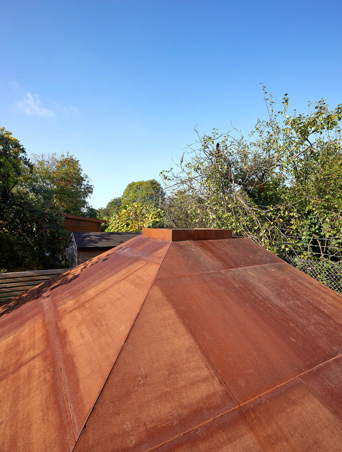 RISE Design Studio built sunken garden studio with rusted steel to provide a hidden place to escape