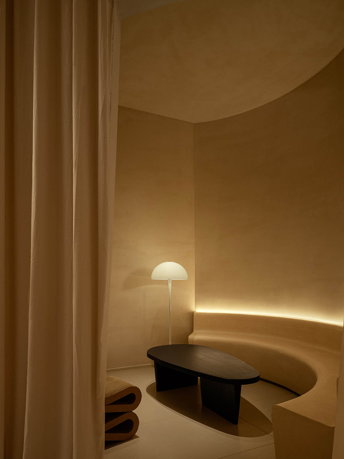 Tea house interiors wrapped by earth-toned fabric curtains act like 