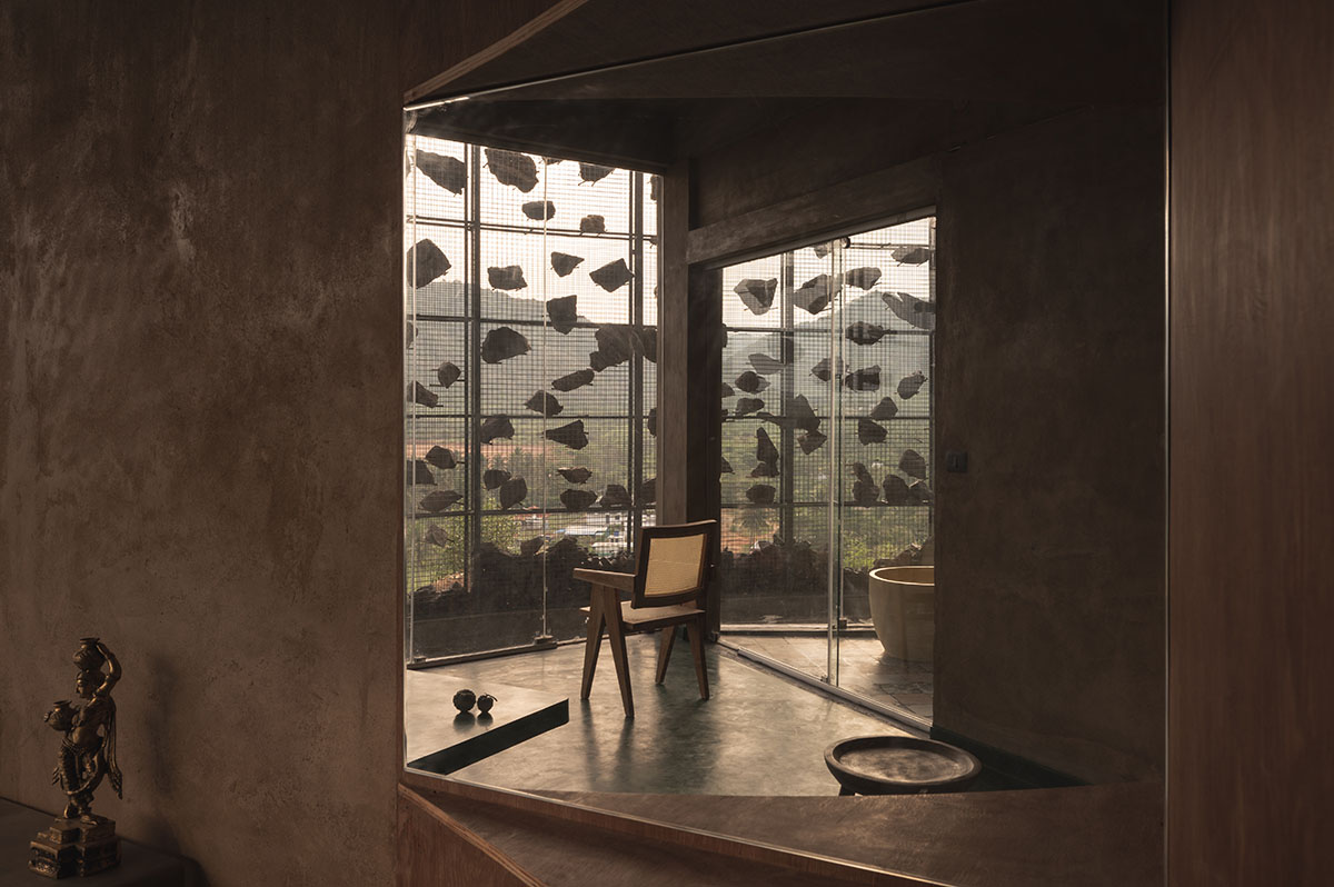 Farm house by Earthscape Studio is wrapped by gabion wall to filter light and airflow in India 