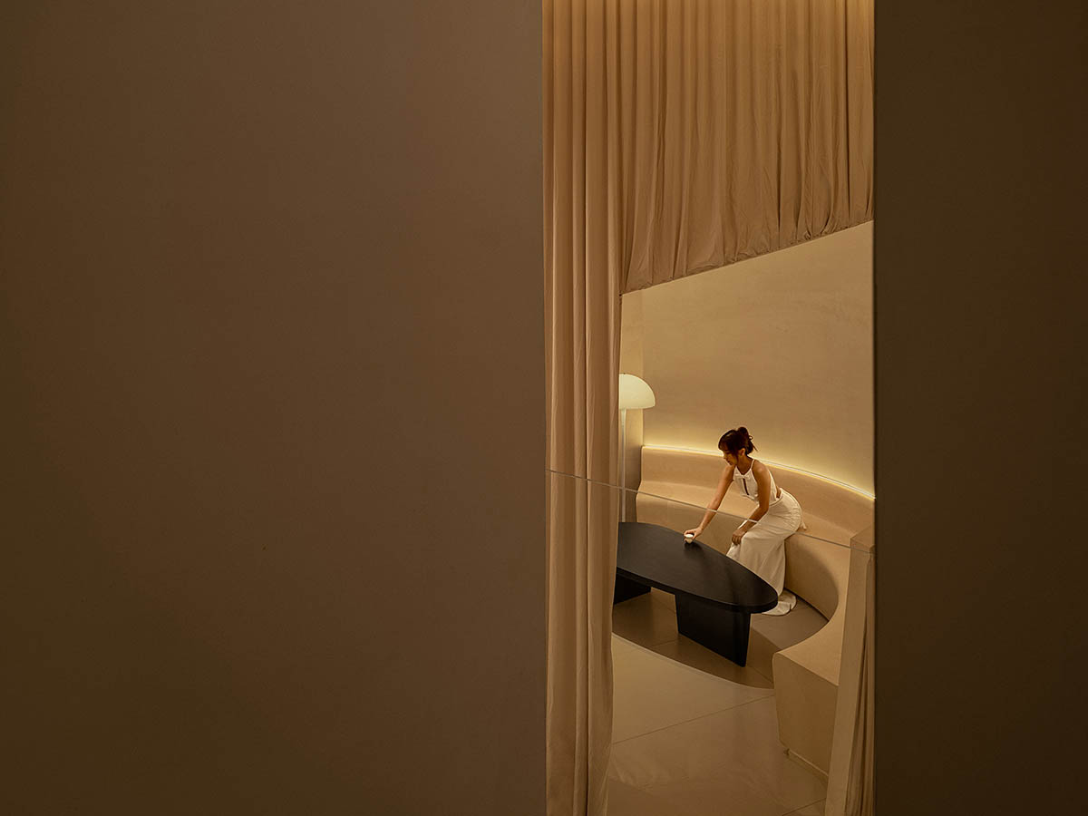 Tea house interiors wrapped by earth-toned fabric curtains act like 