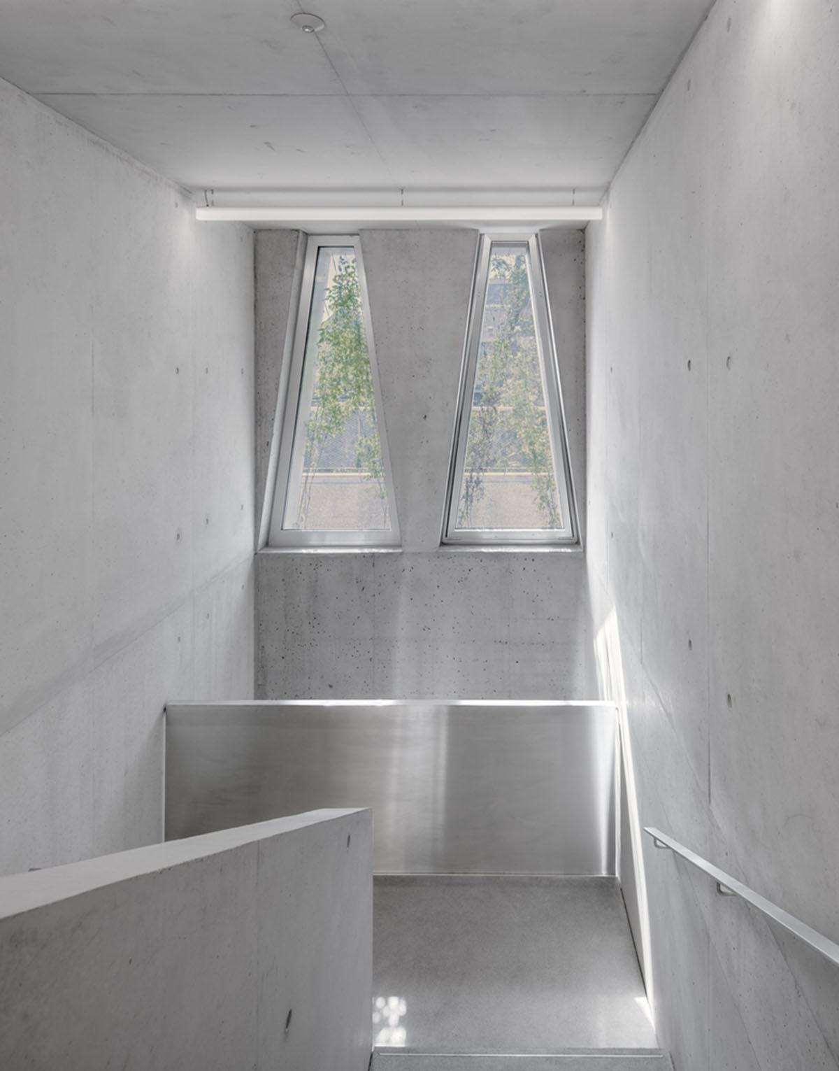 Trapezoidal openings characterize the interiors of cultural center by Estudio Barozzi Veiga in Zürich