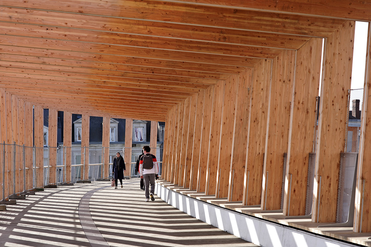 Dietmar Feichtinger Architectes designs curvy bridge made of laminated wood beams in Angers, France