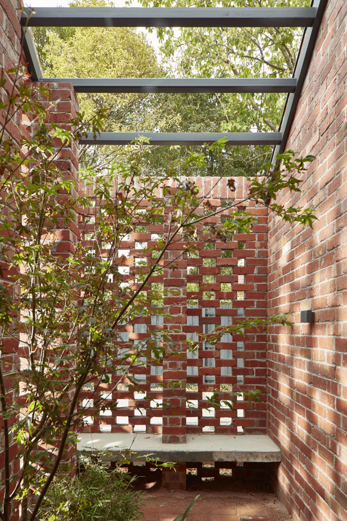 Recycled brick screens wrapping these two dwellings help thermal comfort in a suburb of Australia