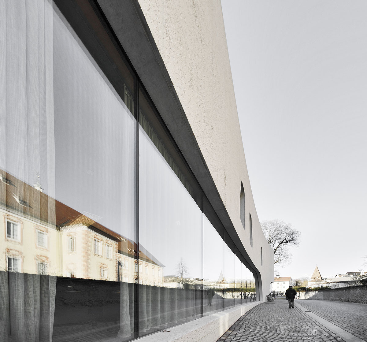 MoDusArchitects wraps public space with sinuous curves for an office building in Bolzano, Italy