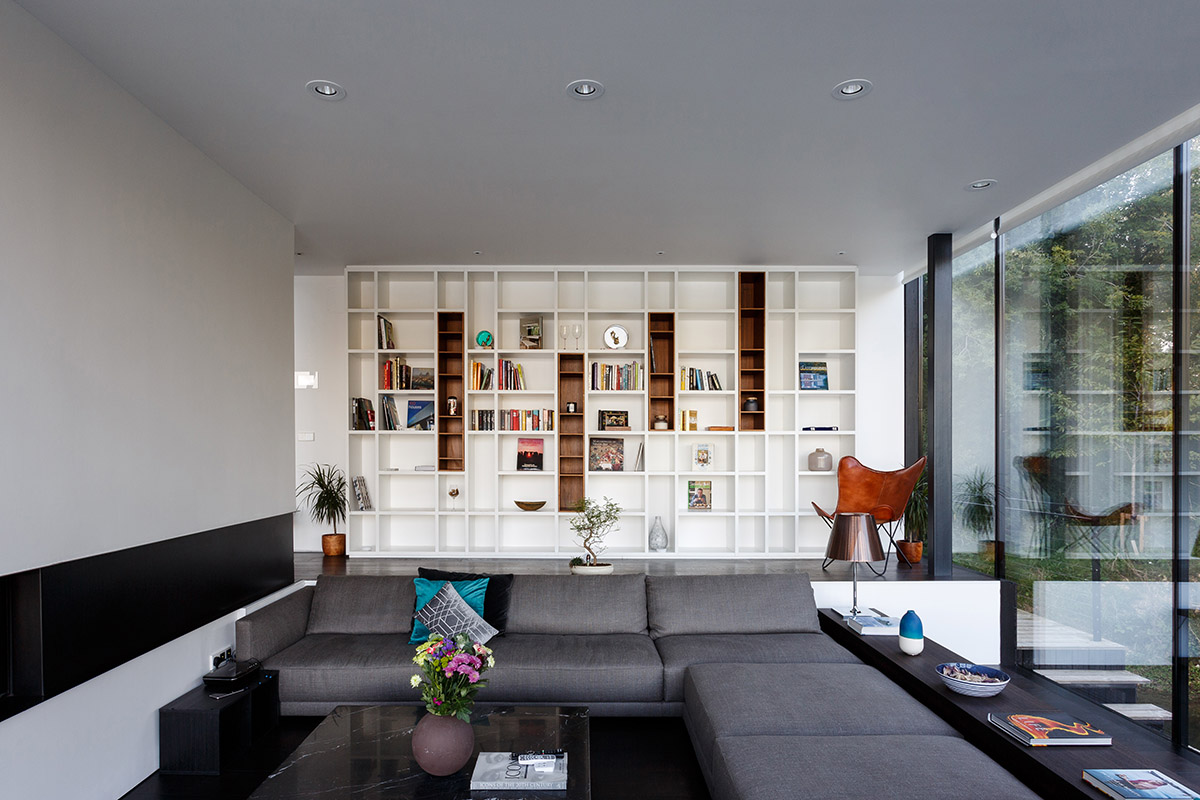 Mecanoo completes glass villa with dark stripes on a lake in Lechlade