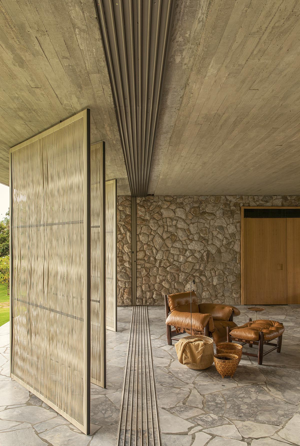mf+arquitetos brings lightness to stone house with wooden louvres in Brazil 