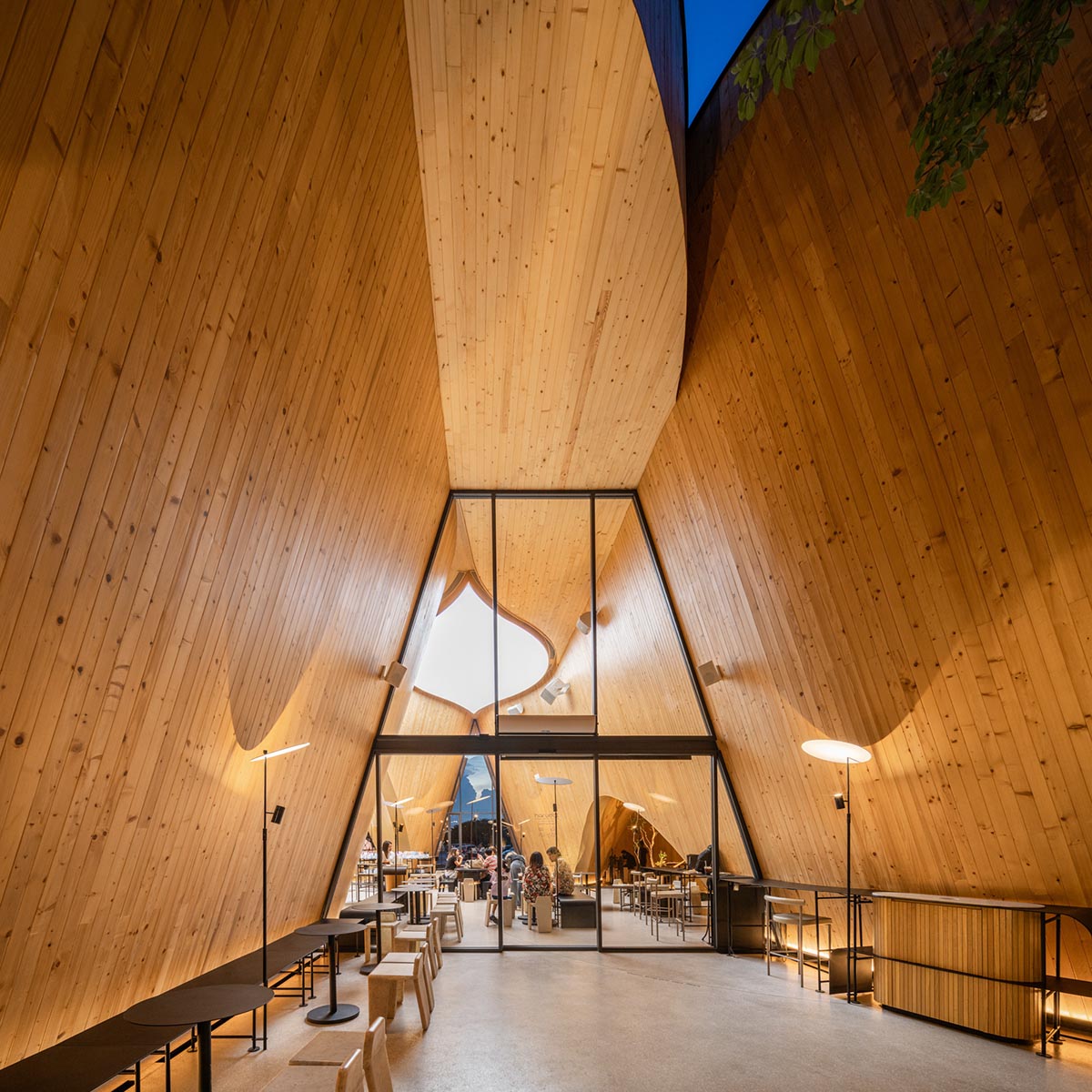 A baobab tree informs a cafe featuring three gable and fluid forms in Thailand by IDIN Architects