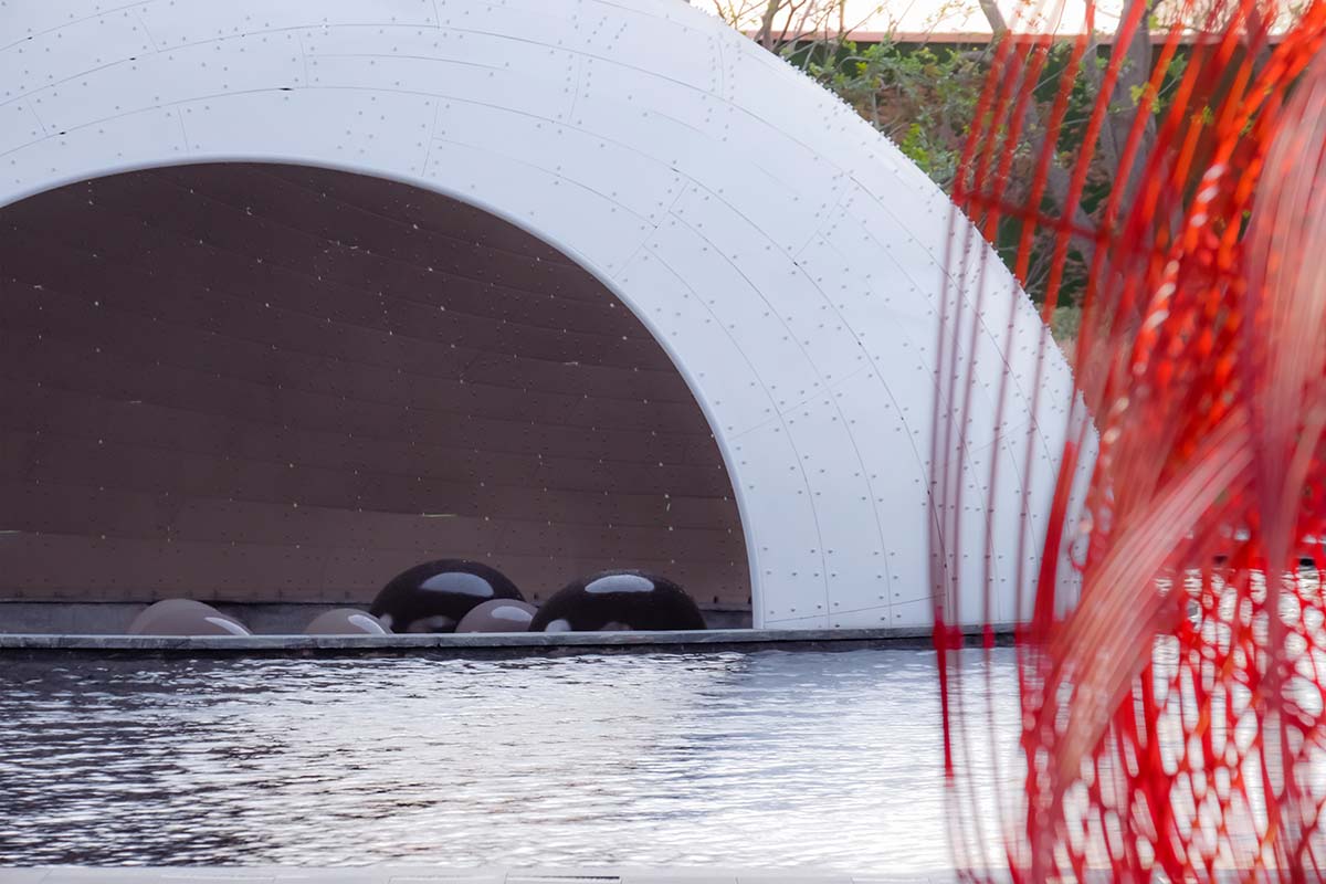   A thin-shell pavilion inspired by the bionic weaving appearance of birds' nests sits on a pool 