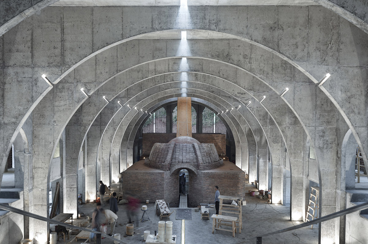AZL Architects renovates old kiln building with concrete and brick arches in the middle of a forest
