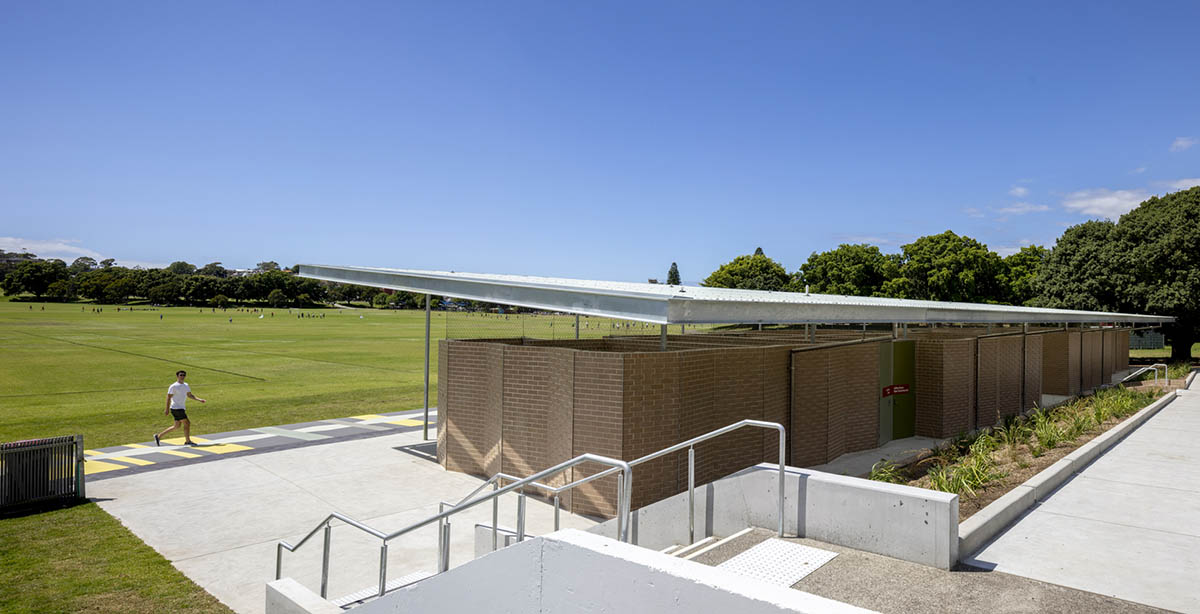 Sports pavilion is made of zigzagging brick walls referencing serrated leaves of endangered banksia