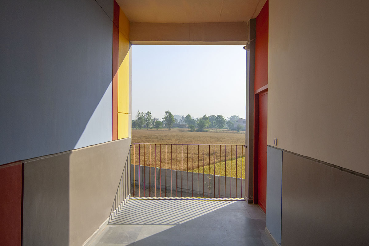 Kamat & Rozario Architecture built school with fortress-like blank walls and colored bridges