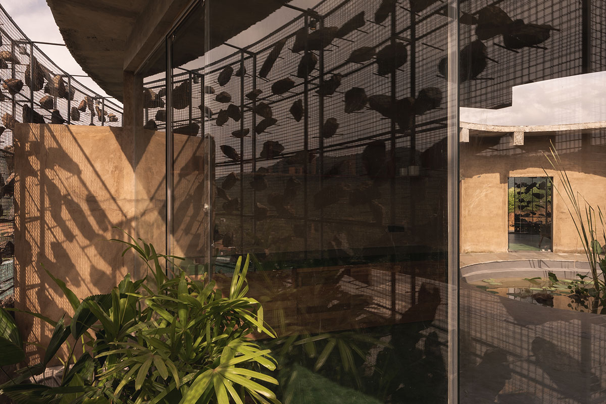 Farm house by Earthscape Studio is wrapped by gabion wall to filter light and airflow in India 