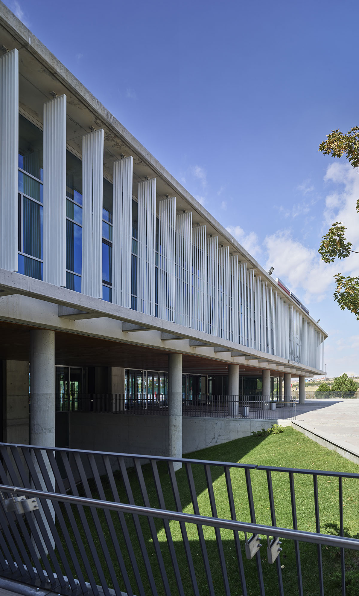 Uygur Architects articulates performing arts center façade with wooden triangulating surfaces