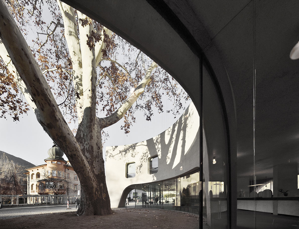 MoDusArchitects wraps public space with sinuous curves for an office building in Bolzano, Italy