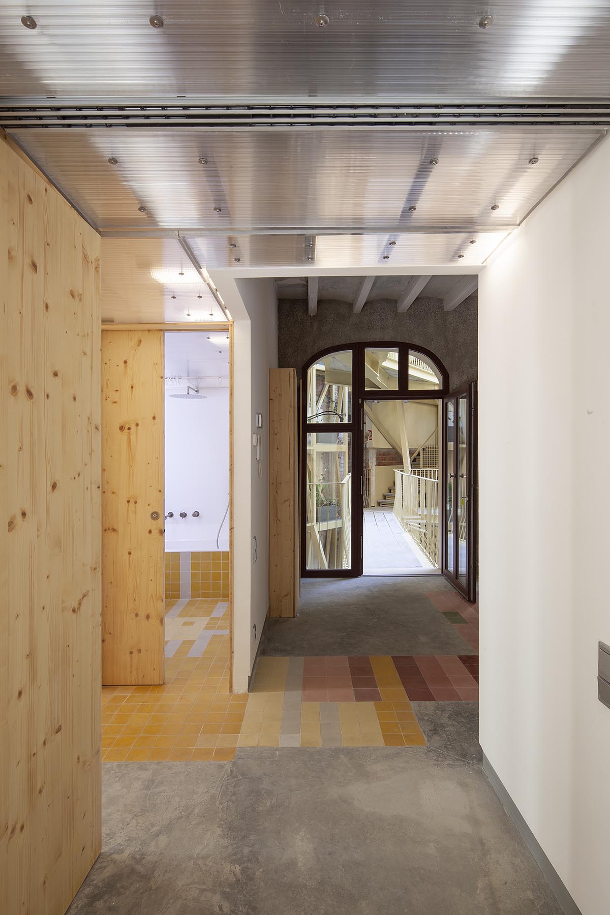 La Carboneria housing block features a dramatic courtyard with crossing beams in Barcelona