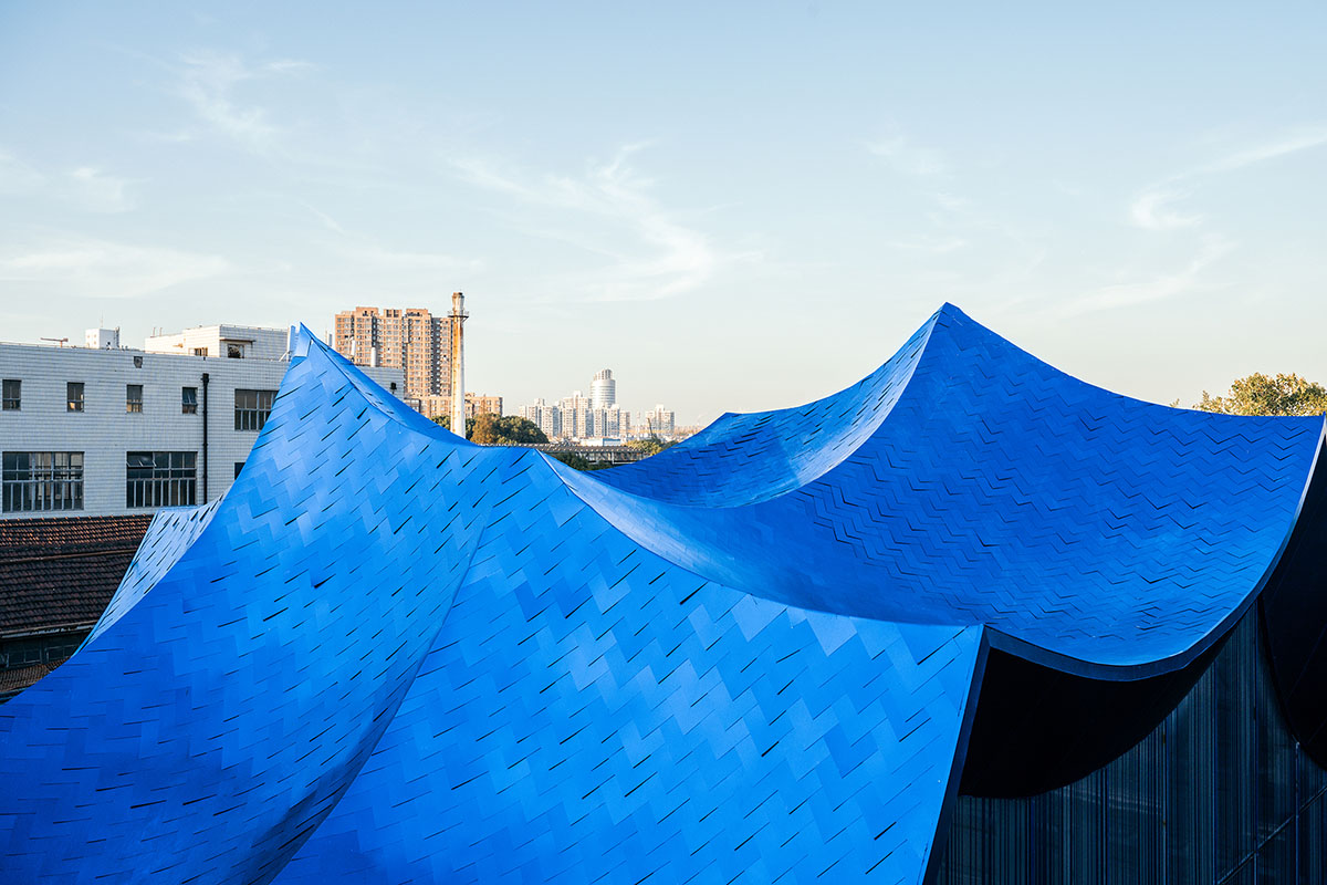 Wutopia Lab converts old roof-covered stockyard and duty room into wave-shaped community hub