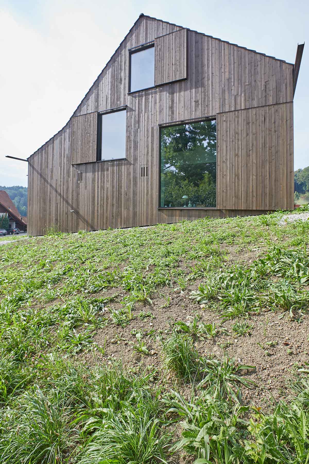 Residential barn features an unfinished, raw interior in Swiss rural landscape